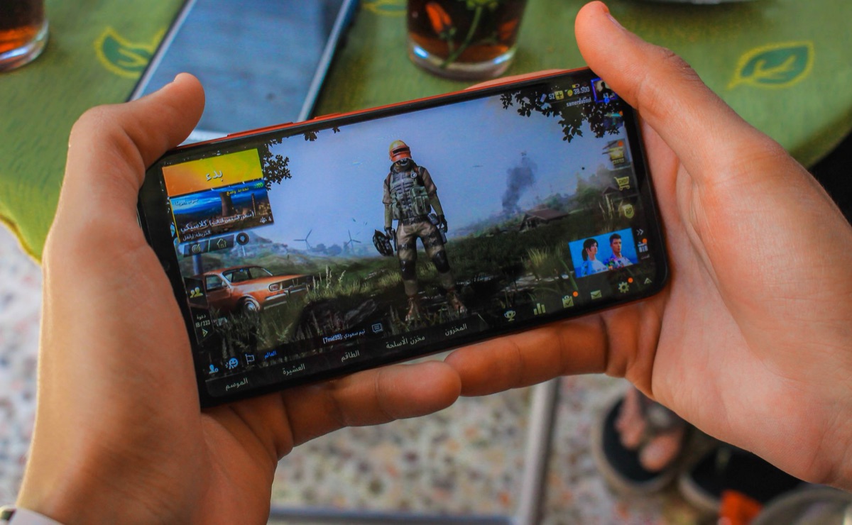 Close up of a hand playing a mobile battle royale game on a smartphone
