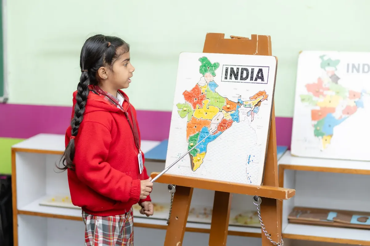 若き生徒がインドの地図を指し示しながら教室で教育を促進する
