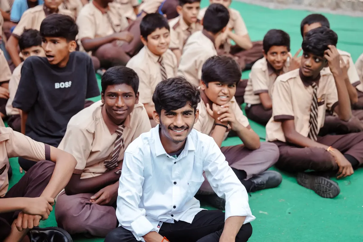 Smiling group of students attending a school event outdoors in Hyderabad, India.