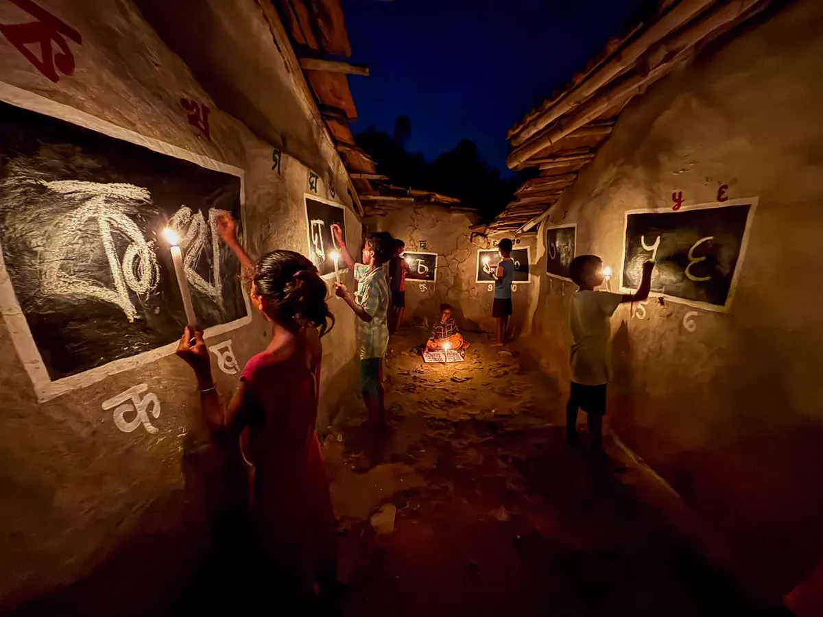 Children learning by candlelight in a rural Indian village at night, embracing education.